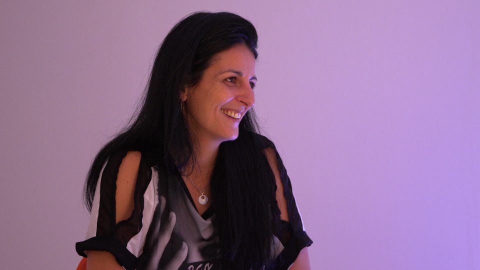 Claire Pierrugues, gérante du Monaix, souriante avec une blouse noire et cheveux longs bruns.