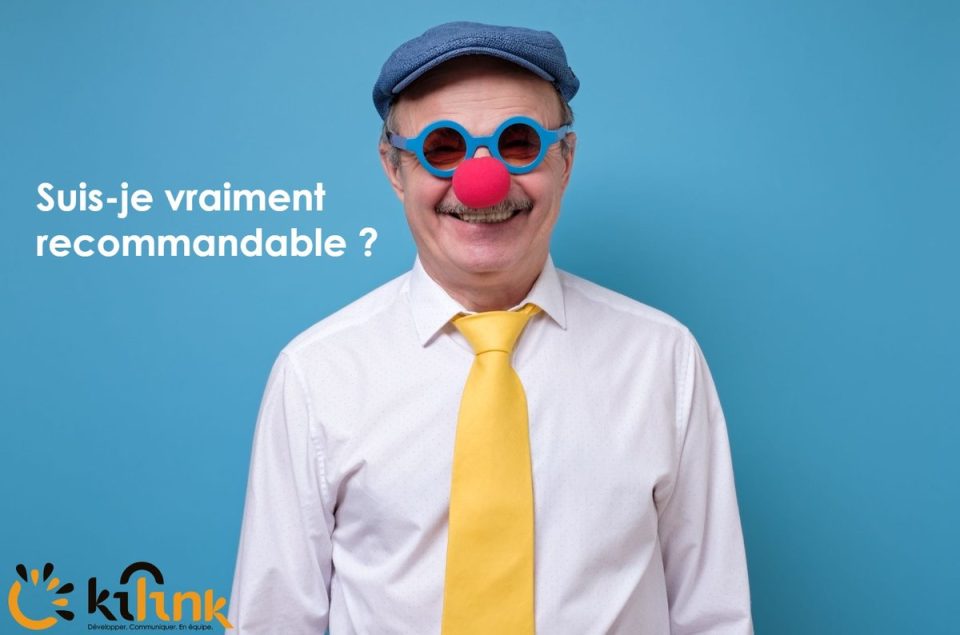 Homme âgé souriant en costume blanc, cravate jaune, chapeau bleu, lunettes rondes et nez de clown, avec texte 'Suis-je vraiment recommandable?' sur fond bleu.