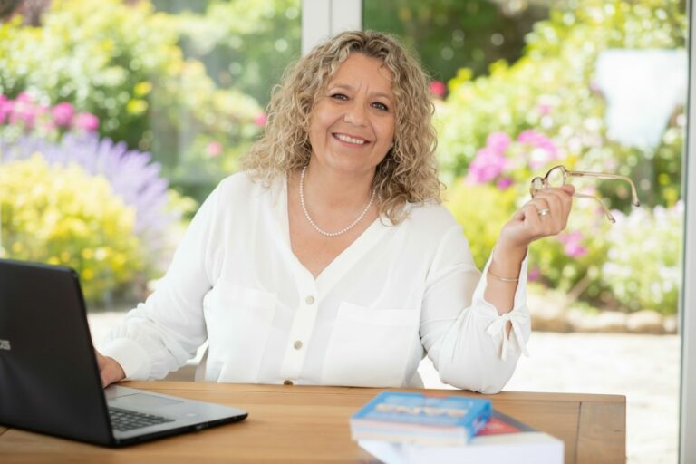 Céline Maccotta Cegonnes, experte en communication B2B, souriante à son bureau avec un ordinateur et des ouvrages professionnels